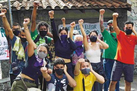 The deaf student community raises one hand and covers their ears with the other, as a symbol of ¨Deaf Power¨, during a protest organised by the deaf and hard-of-hearing students community on March 11, 2021 in Medellin, Colombia.